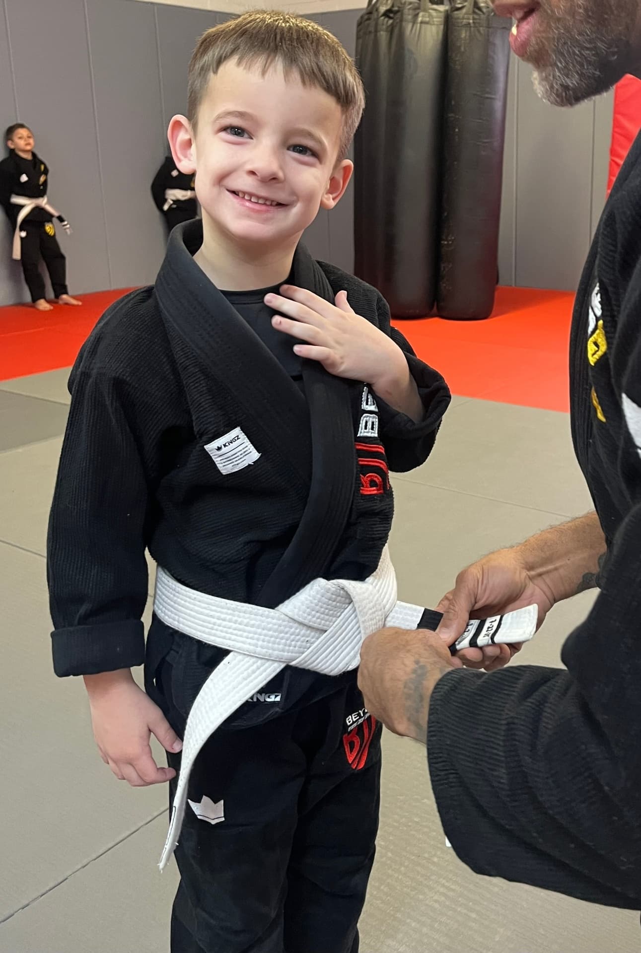 Young student receiving stripe during belt ceremony at Beyond BJJ